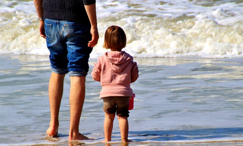 Step father and child get to know each other on the beach
